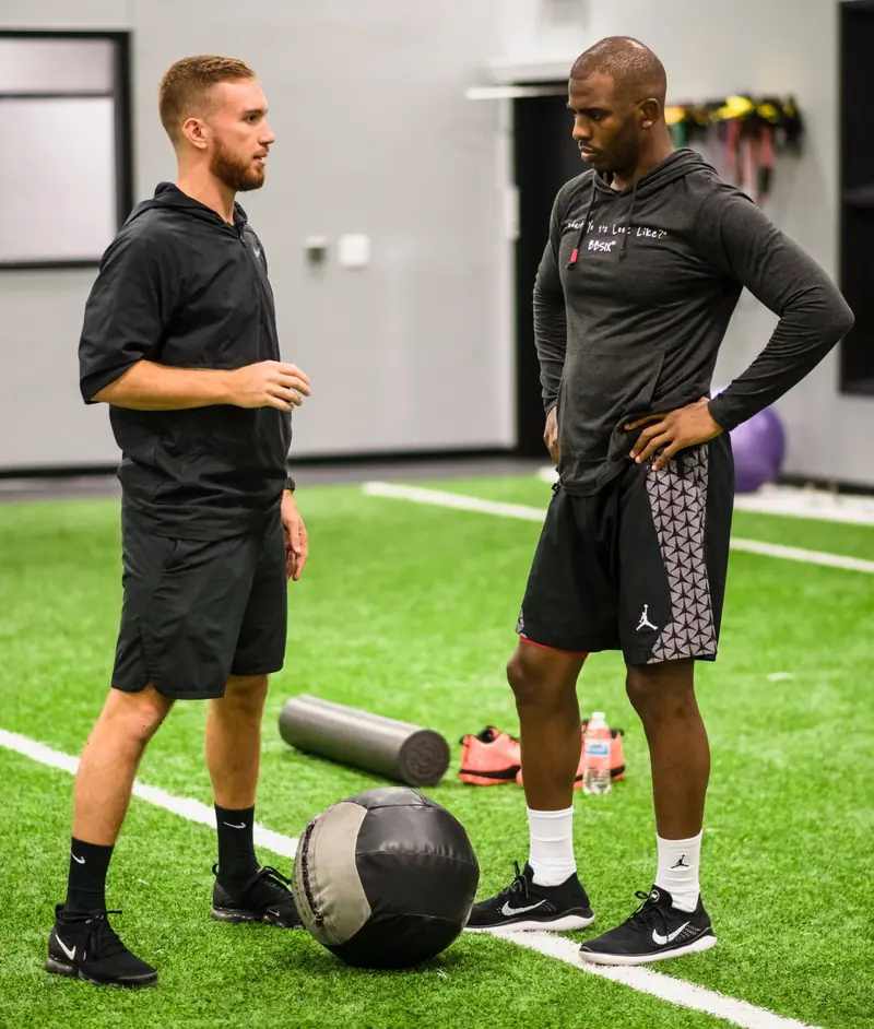 Matt Wilkins coaching Chris Paul on a turf training floor